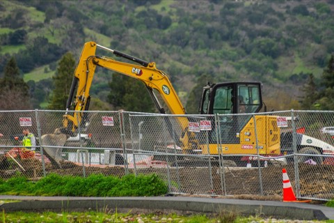 CAT excavator on a fenced construction site