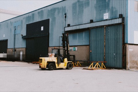 Forklift positioned outside an industrial warehouse