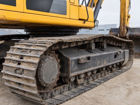 Close view of excavator tracks, rollers, sprocket and undercarriage frame