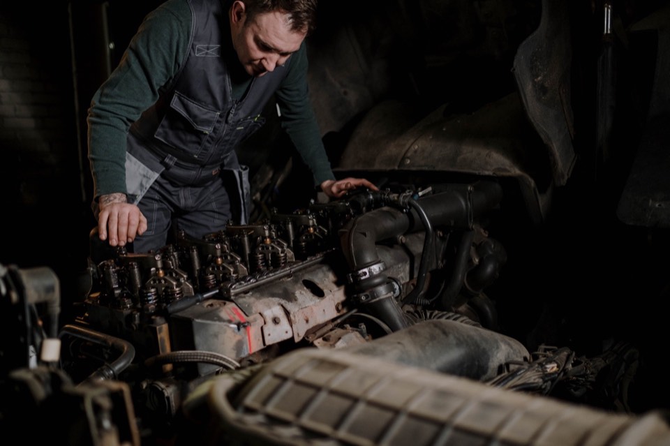 Technician working on a heavy-duty diesel engine during a repair