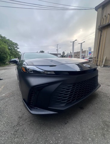 Dark grey 2025 Toyota Camry photographed from a low front angle